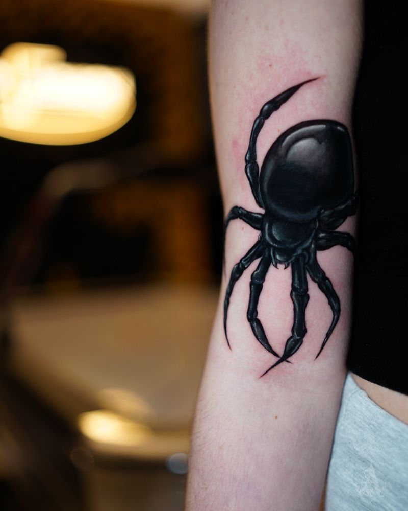 Tatuaje de araña en negro sólido en el brazo, blackwork en negro y gris