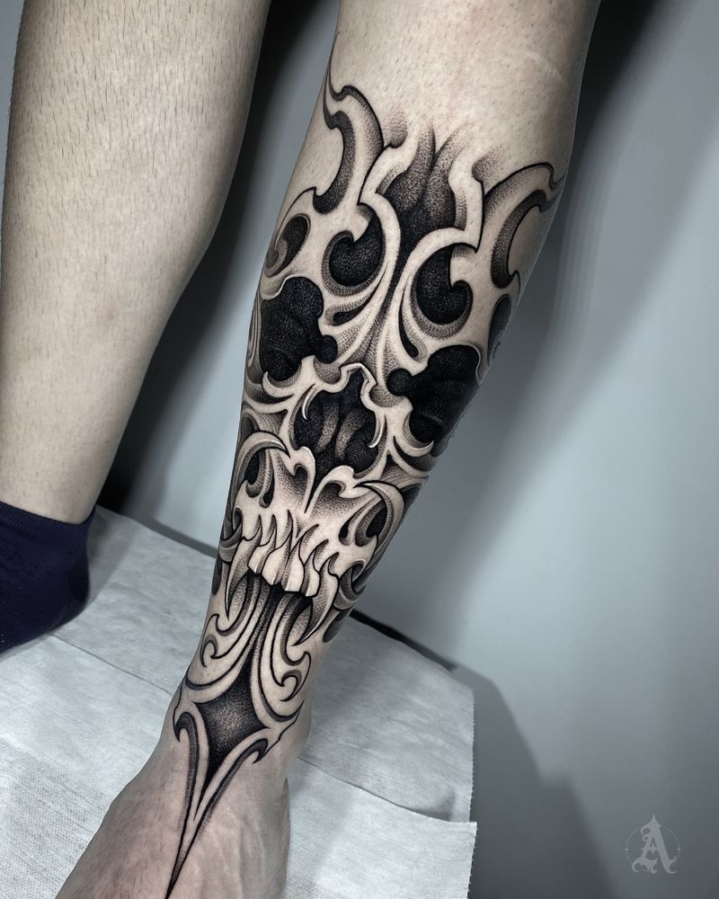 Tatuaje de ornamento en negro sólido en pantorrilla, blackwork en negro y gris