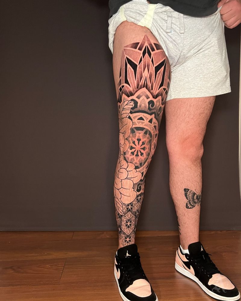 Tatuaje dotwork de mandalas en cadena en la pierna, puntillismo en negro