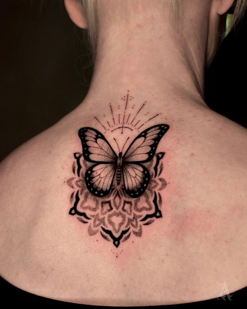 Tatuaje dotwork de mariposa geométrica en la nuca, puntillismo en negro