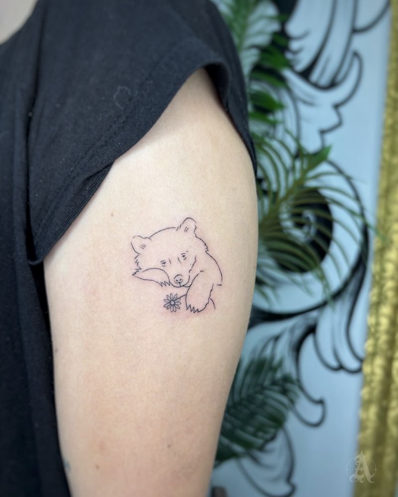 Tatuaje de oso con flor en el brazo, fine line en negro y gris