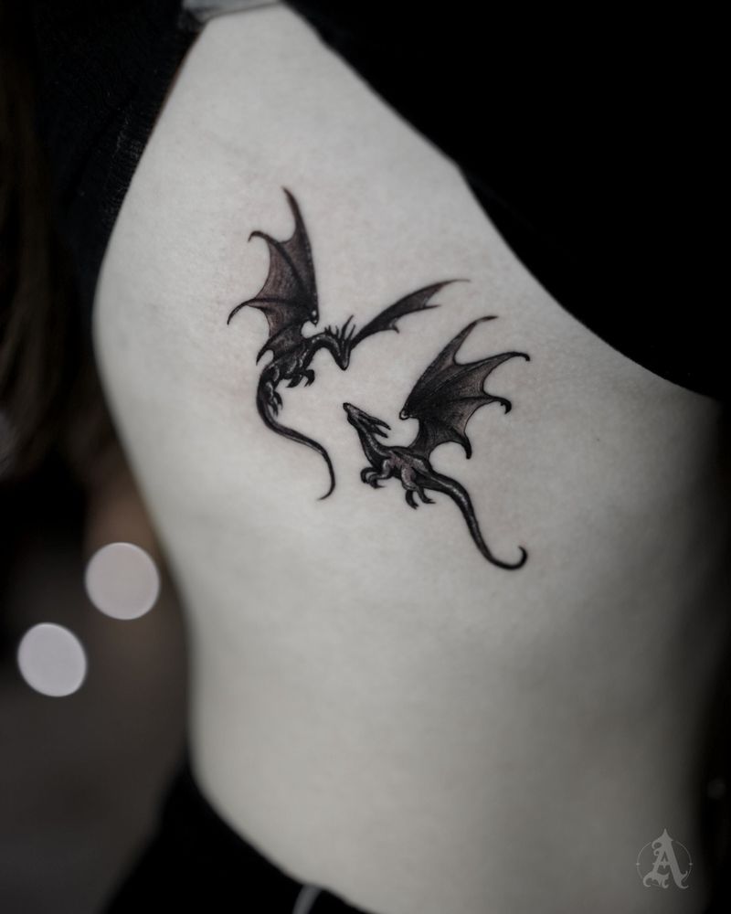 Tatuaje de dos dragones diminutos en las costillas, fine line en negro y gris