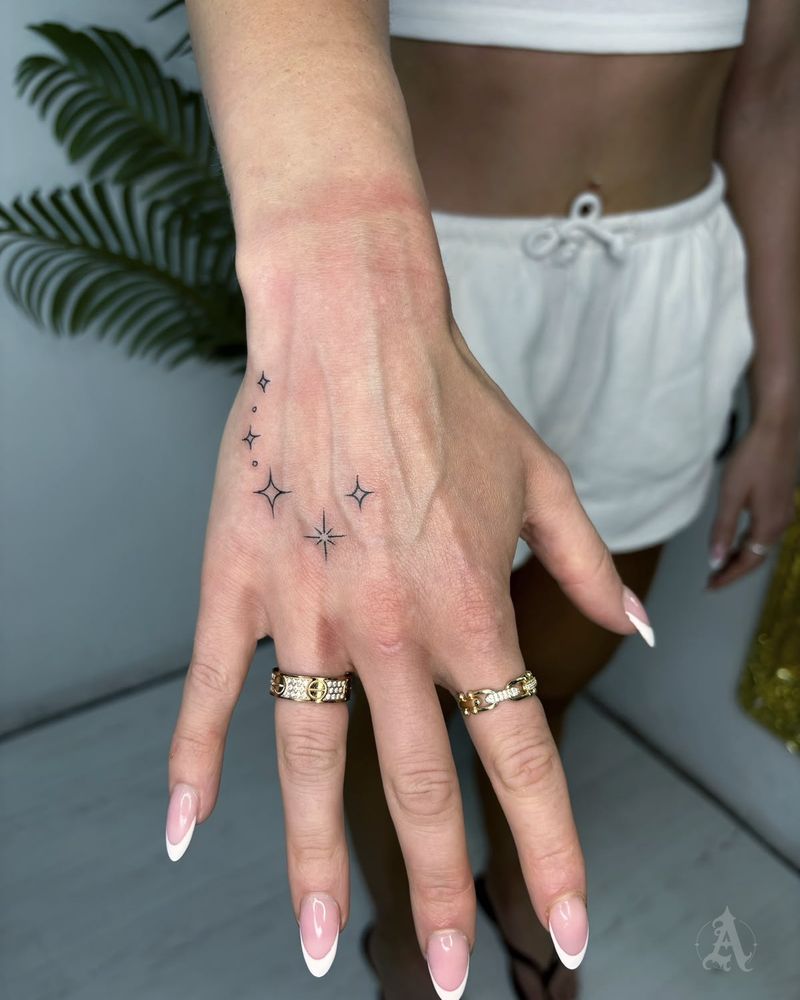 Tatuaje de estrellas en la mano en la mano, fine line en negro y gris