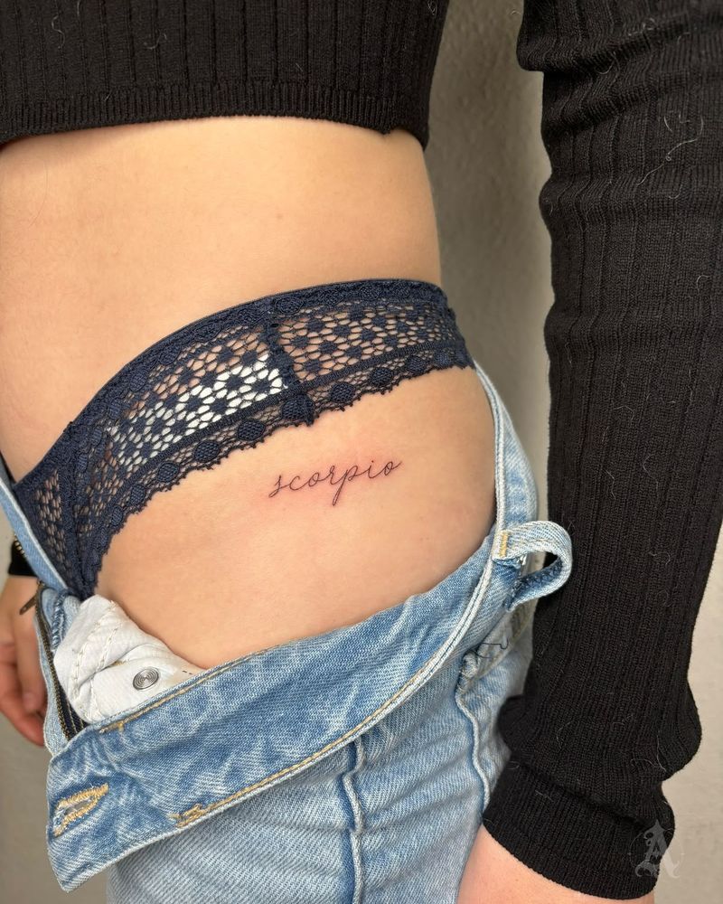 Tatuaje de signo zodiacal manuscrito en la cadera, fine line en negro y gris
