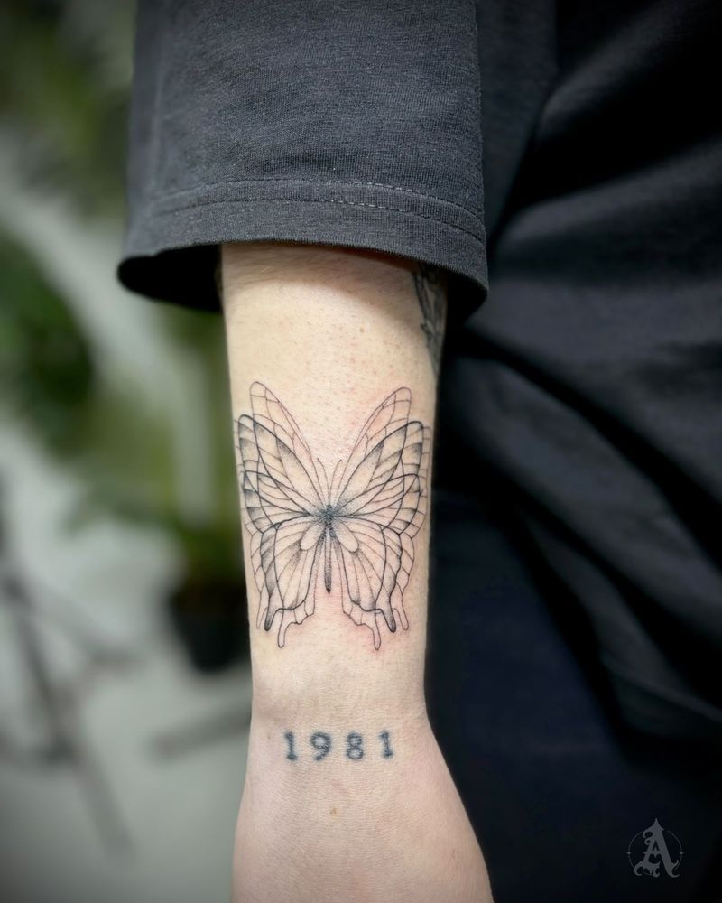Tatuaje de mariposa y año en la muñeca, fine line en negro y gris