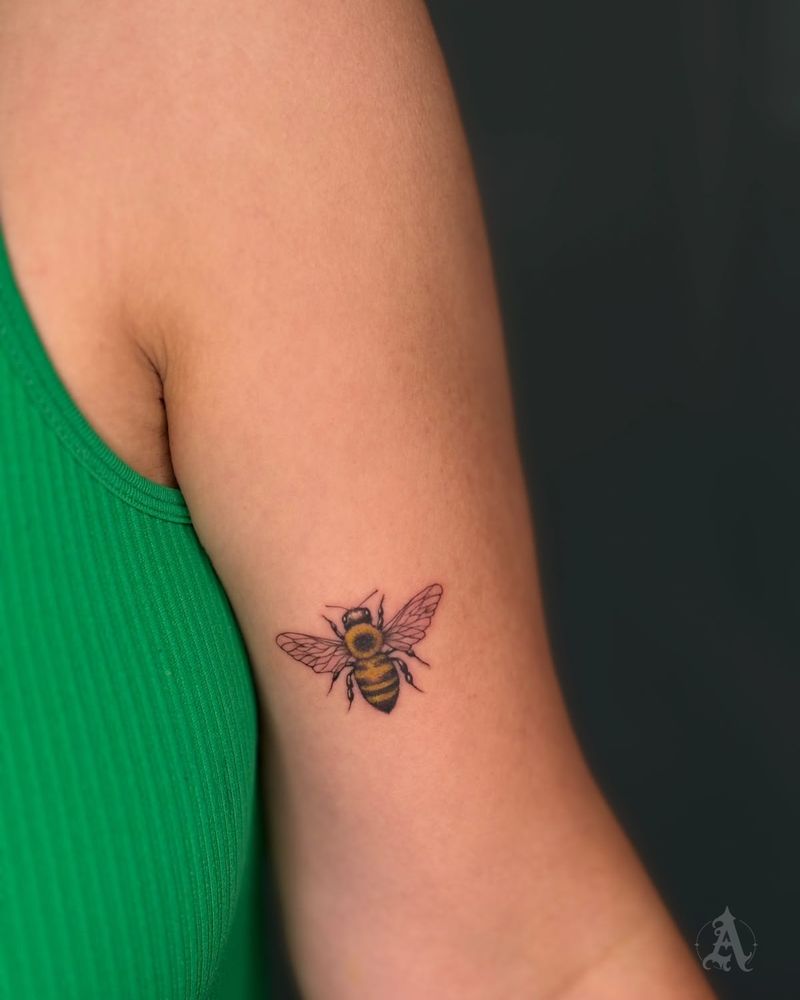 Tatuaje de abeja en el brazo, fine line en negro y gris