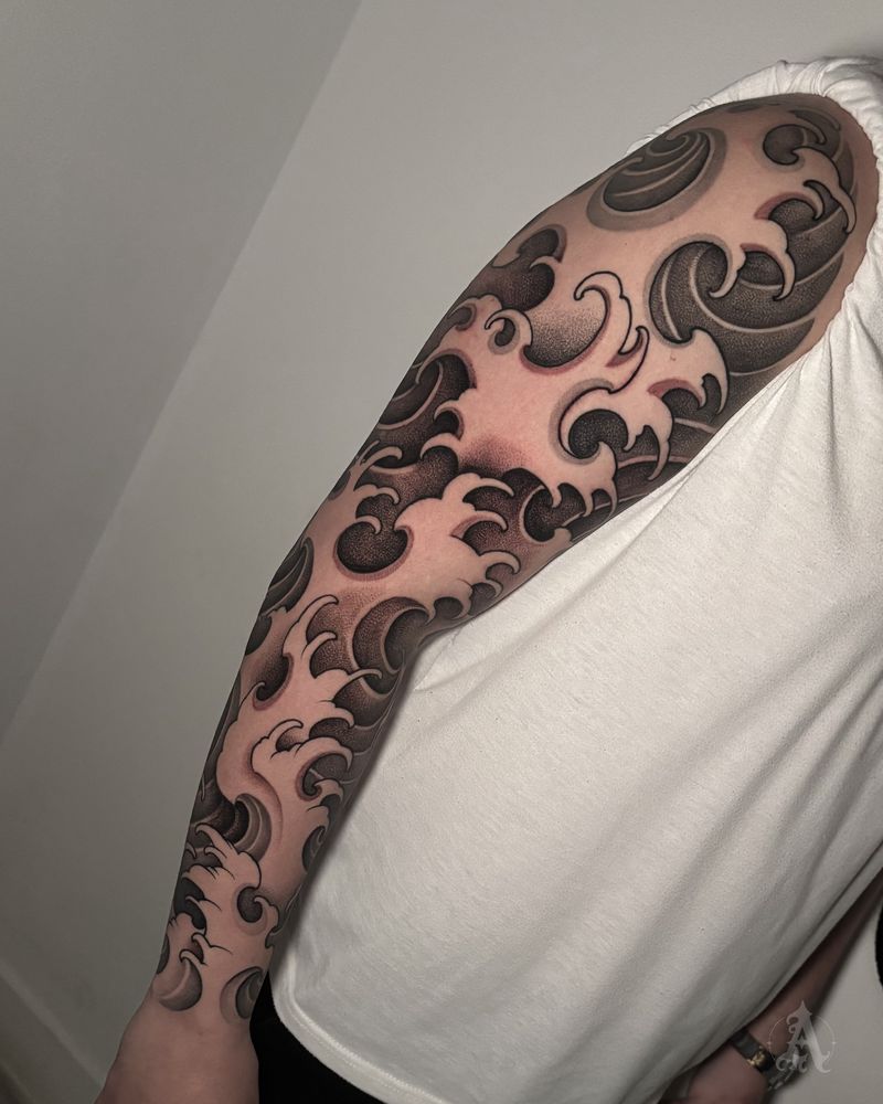 Tatuaje de nubes y olas en brazo completo, japonés en negro y gris