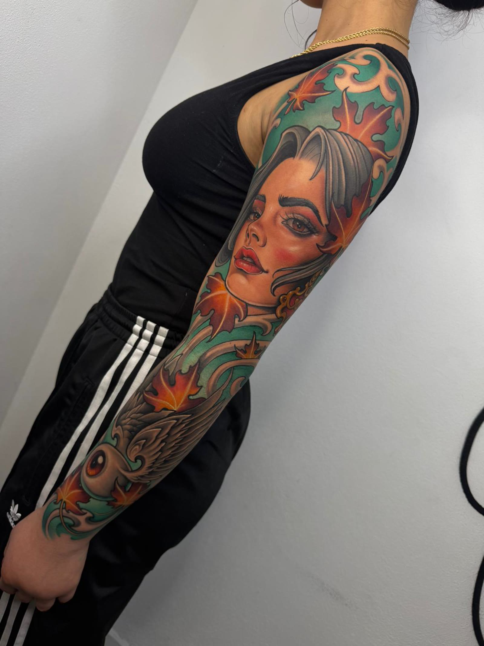 Tatuaje Neotradicional a color de una mujer con ojo y alas en brazo completo