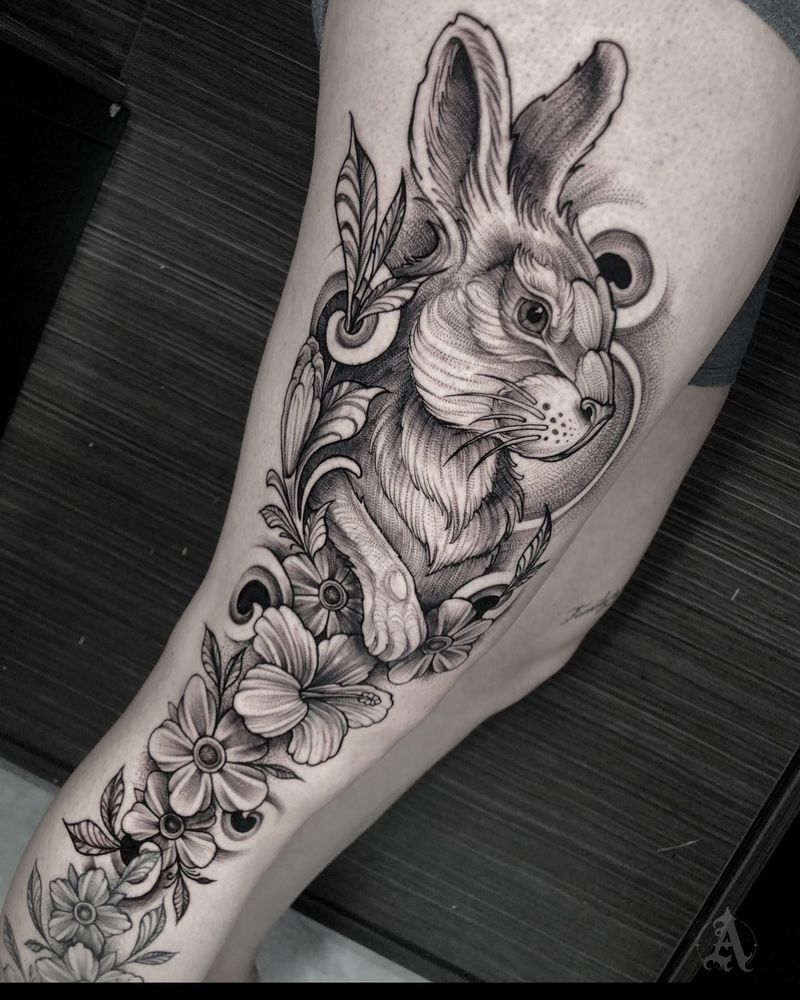 Tatuaje de conejo entre flores en muslo, realismo en negro y gris
