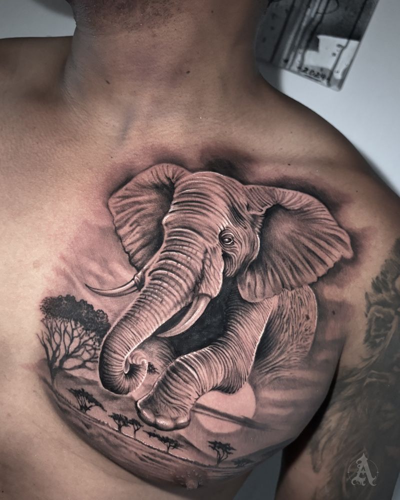 Tatuaje de elefante y paisaje en pecho, realismo en negro y gris