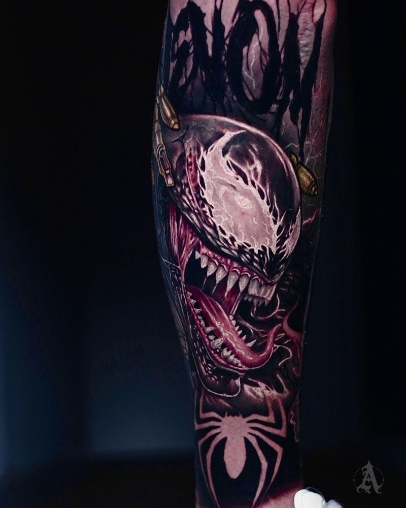 Tatuaje realista de Venom a color en la pierna, con la araña de Spider-Man debajo